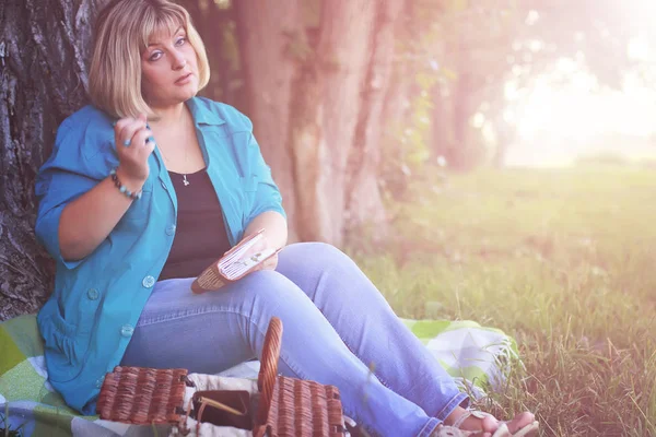 kadın parkta günbatımı kitap ile