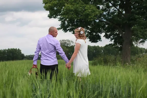 Couple amoureux marchant dans le champ dans la journée d'été — Photo