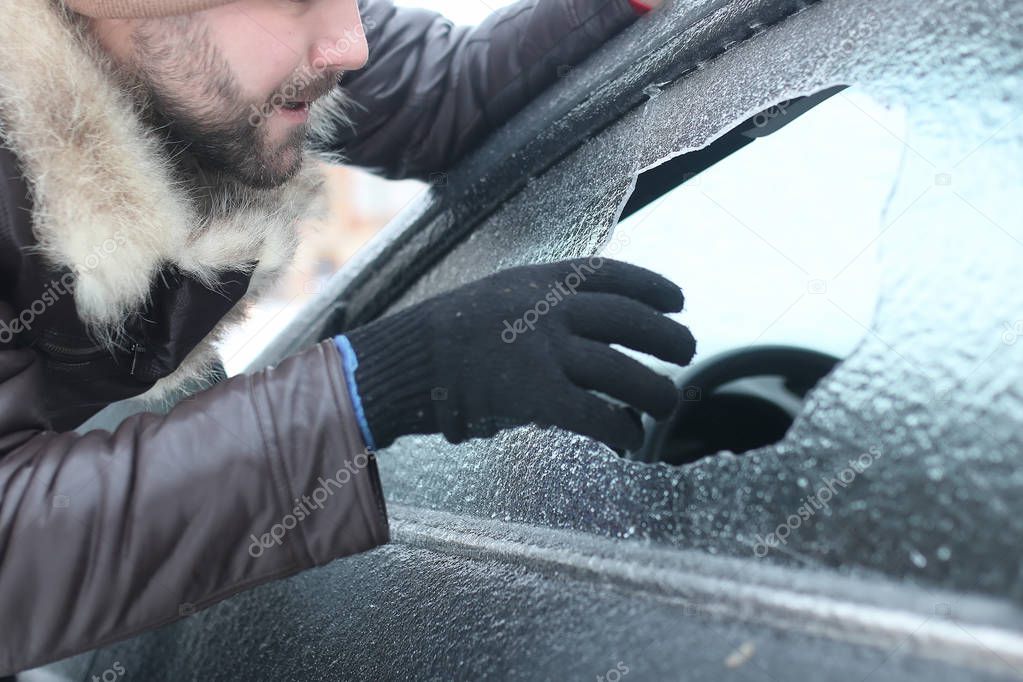 man broke the glass of the car a little stone