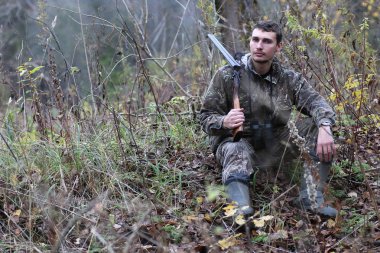 Kamuflaj ve bahar hun üzerinde orman Kuşağı'nda silahlı adam