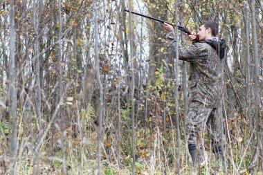 Kamuflaj ve bahar hun üzerinde orman Kuşağı'nda silahlı adam