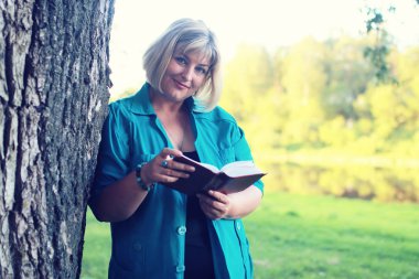 kadın yatıyordu ve kitap Güneş okuyun