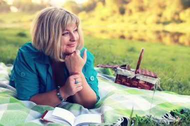 kadın yatıyordu ve kitap Güneş okuyun