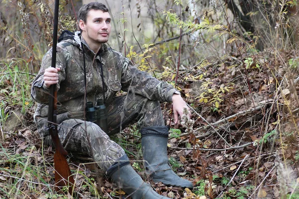 Homem em camuflagem e com armas em um cinto florestal em um hun primavera — Fotografia de Stock
