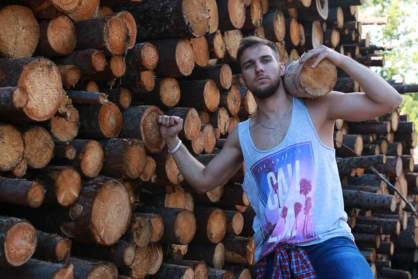 Um homem na fábrica a processar madeira, a serrar troncos — Fotografia de Stock