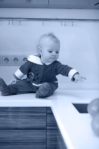 Fekete-fehér fénykép, a konyhában kis gyermek ül egy asztal — Stock Fotó