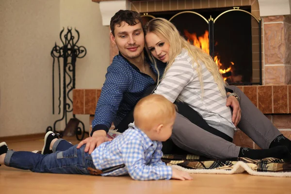 Familie wärmt sich am Kamin auf der Couch — Stockfoto