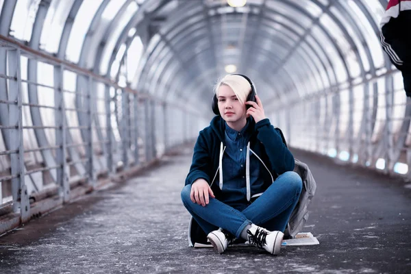 在地铁里大耳机听音乐的年轻学生 — 图库照片