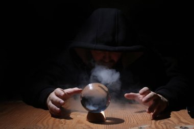 adam siyah başlıklı cristal topu ile