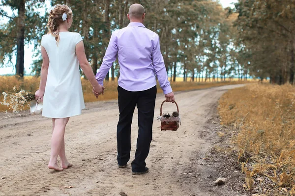 Bara gift älskare promenader i ett fält i höstdag — Stockfoto