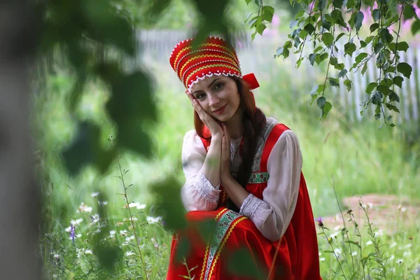 Σλαβική σε παραδοσιακό φόρεμα κάθεται στη φύση — Φωτογραφία Αρχείου