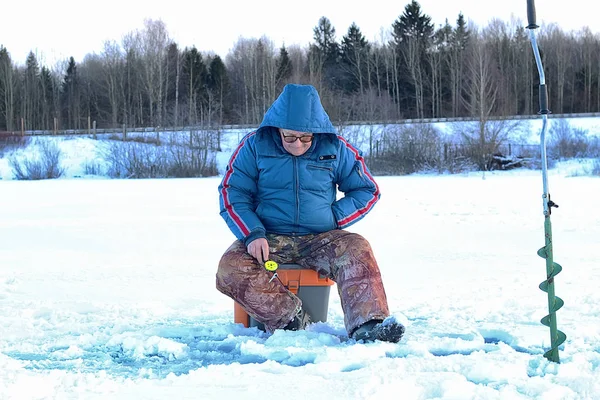 Anciano pescando en el invierno en el lago — Foto de Stock