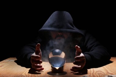 adam siyah başlıklı cristal topu ile