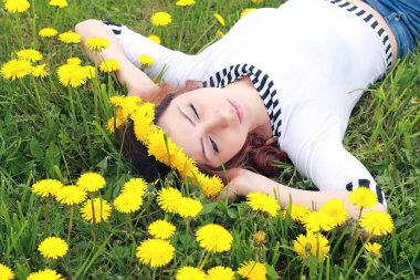 Sarı dandelions çayırda güneşli bir dinlenme kız