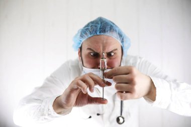 Beyaz önlük ve eski şırınga çılgın sakallı doktor