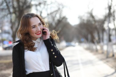 İş kadını elbiseli cep telefonu açık havada
