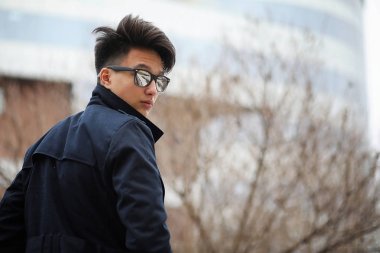 Asya genç adam sokakta bir ceket