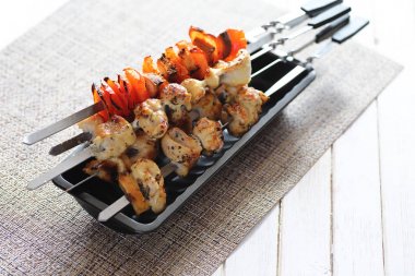 Pişmiş sebze ile metal şiş üzerinde kebap