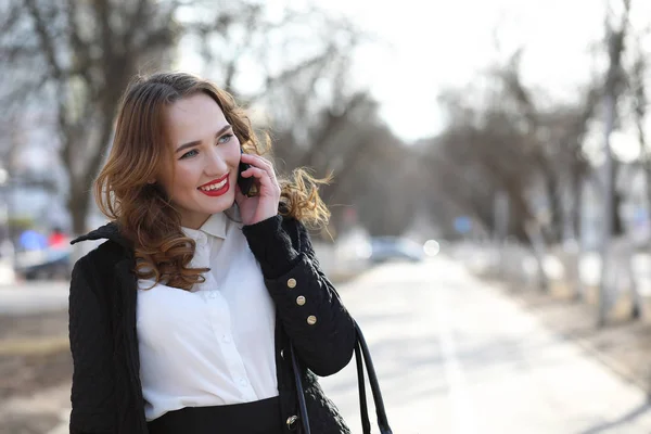 Forretningsdame i dress utendørs med mobiltelefon – stockfoto