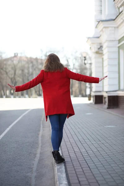 街で赤いコートで散歩できれいな女の子 — ストック写真