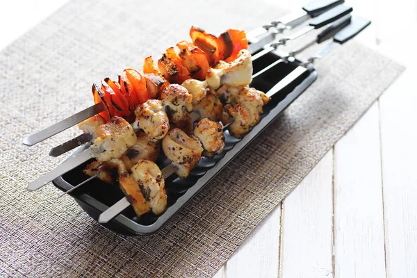 Pişmiş sebze ile metal şiş üzerinde kebap