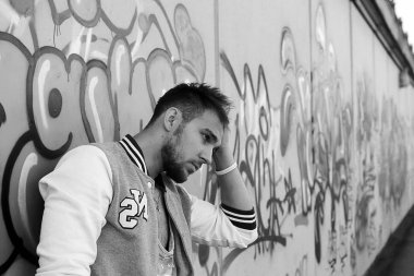 Siyah ve beyaz fotoğraf hip hop tarzı giyinmiş bir adam