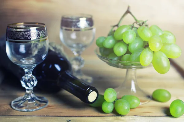 üzüm ve şarap şişesi kitap ile ahşap masa