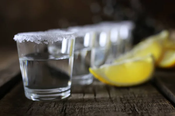 Pile de tequila avec sel et citron sur un fond en bois — Photo