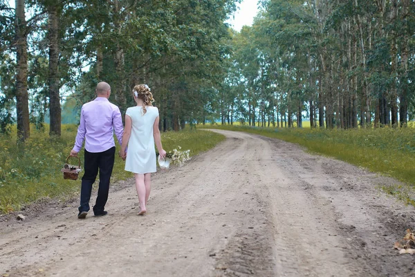 Gli amanti appena sposati che camminano in un campo in giorno di autunno — Foto Stock