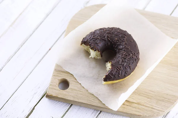 Donut de chocolate em um fundo branco de madeira — Fotografia de Stock