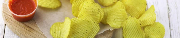 Horizontal bakground of potato chips on a table — Stock Photo, Image