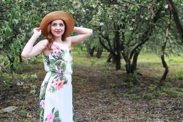 Fille en robe et chapeau de paille dans le parc — Photo