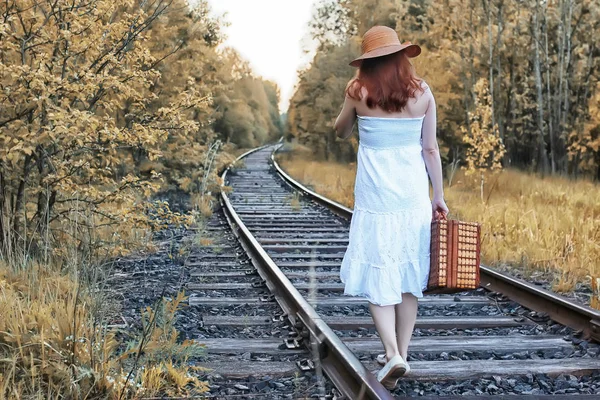 Automne parc fille en blanc robe de soleil et une valise en osier marche — Photo