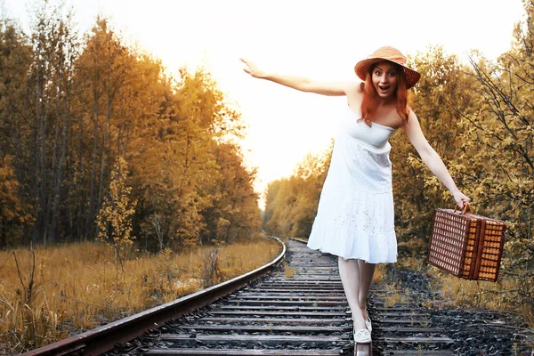 Autunno parco ragazza in sundress bianco e una valigia di vimini a piedi — Foto Stock