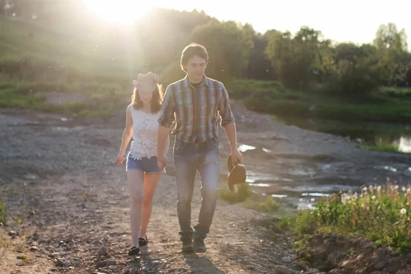 Bahar akşamında gün batımında yürüyen iki genç insan. — Stok fotoğraf
