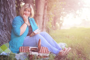 kadın parkta günbatımı kitap ile