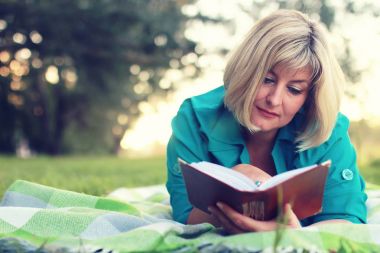 kadın yatıyordu ve kitap Güneş okuyun