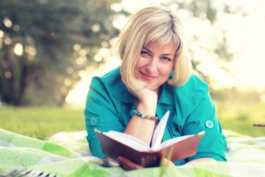 kadın yatıyordu ve kitap Güneş okuyun