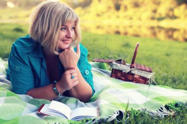 kadın yatıyordu ve kitap Güneş okuyun