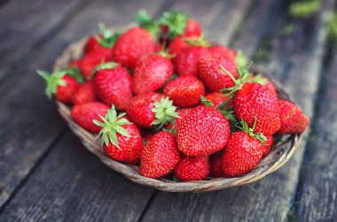 Hasır plaka ahşap arka plan üzerinde çilek