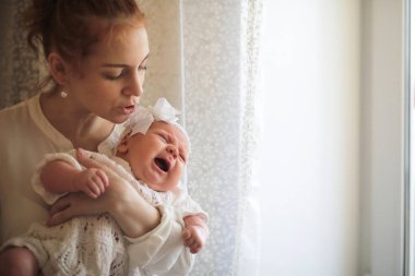 Güzel, genç bir anne kucağında yeni doğmuş kızını