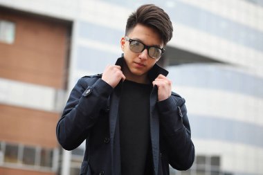 Asya genç adam sokakta bir ceket