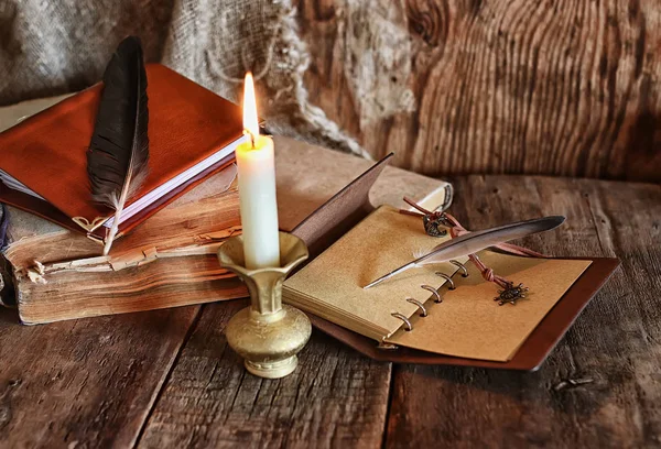 Πούπουλα και φτερά βιβλίο μυθιστόρημα κοντά του ένα κερί — Φωτογραφία Αρχείου