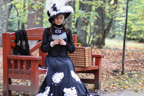 Girl in retro dress past century read letter on the bench — Stock Photo, Image