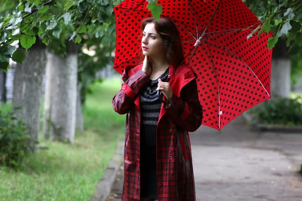 kadın bir yağmurluk ve şemsiye