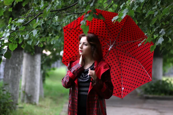 kadın bir yağmurluk ve şemsiye