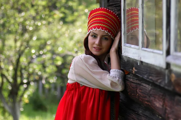 Mujer eslava en la pared de madera vestido tradicional — Foto de Stock