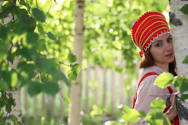 Славянин в традиционной одежде прячется за деревьями — стоковое фото