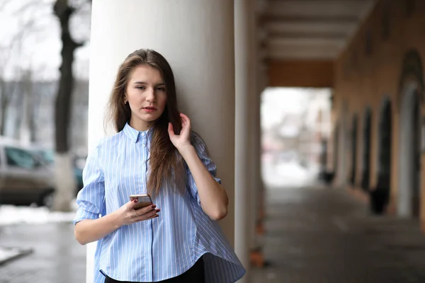 Ung, vakker jente på en spasertur nær bygningen med spalte – stockfoto