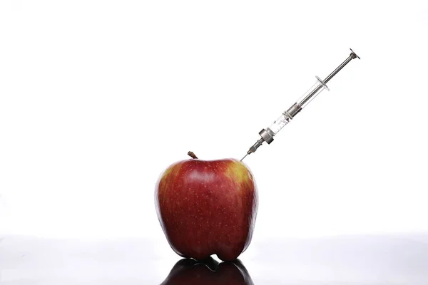 Genetically modified foods, apple pumped with chemicals — Stock Photo, Image